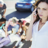 Image of woman on phone at a car accident scene