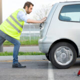 Image of man pushing a car